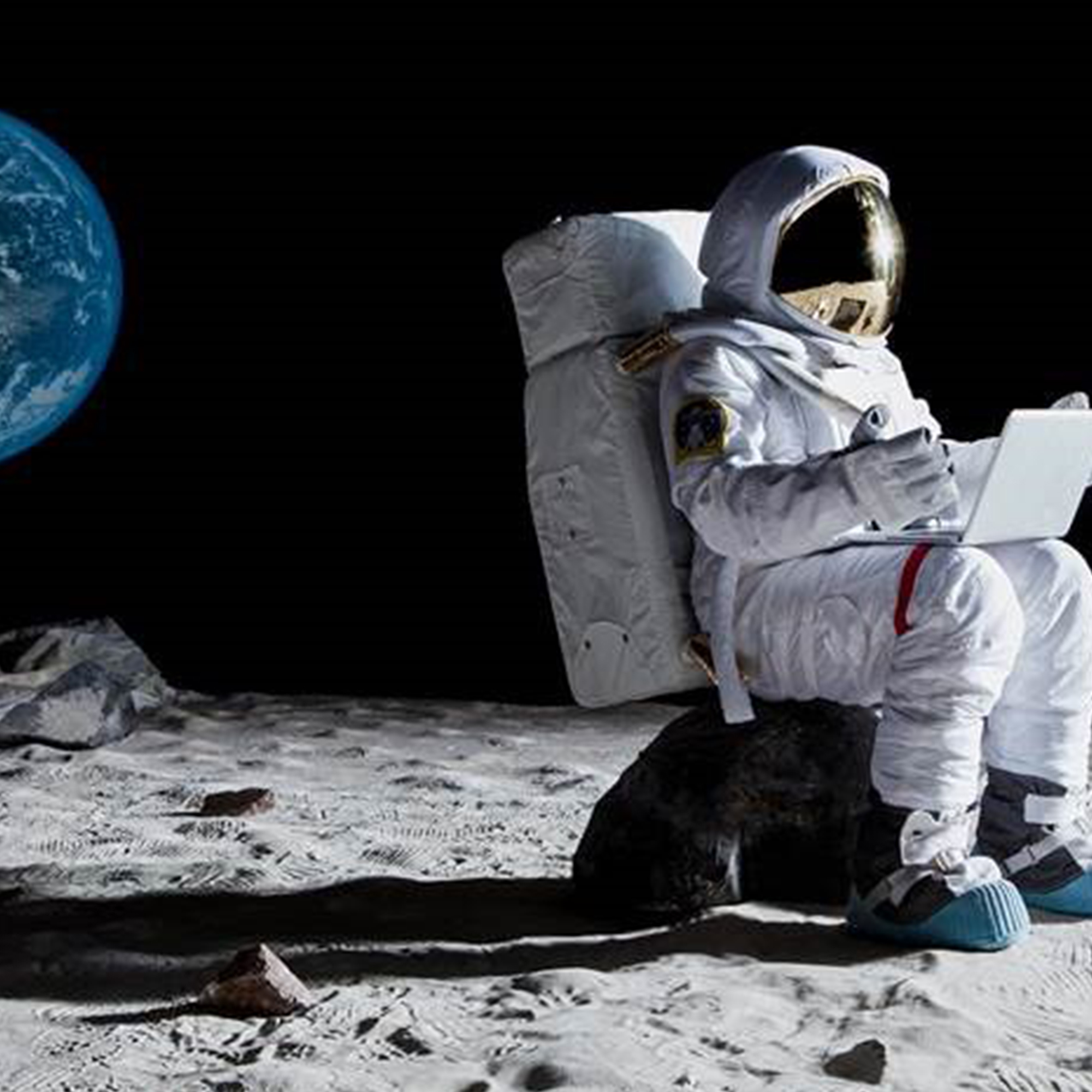 Im Weltall ist ein Astronaut auf dem Mond und arbeitet am Laptop