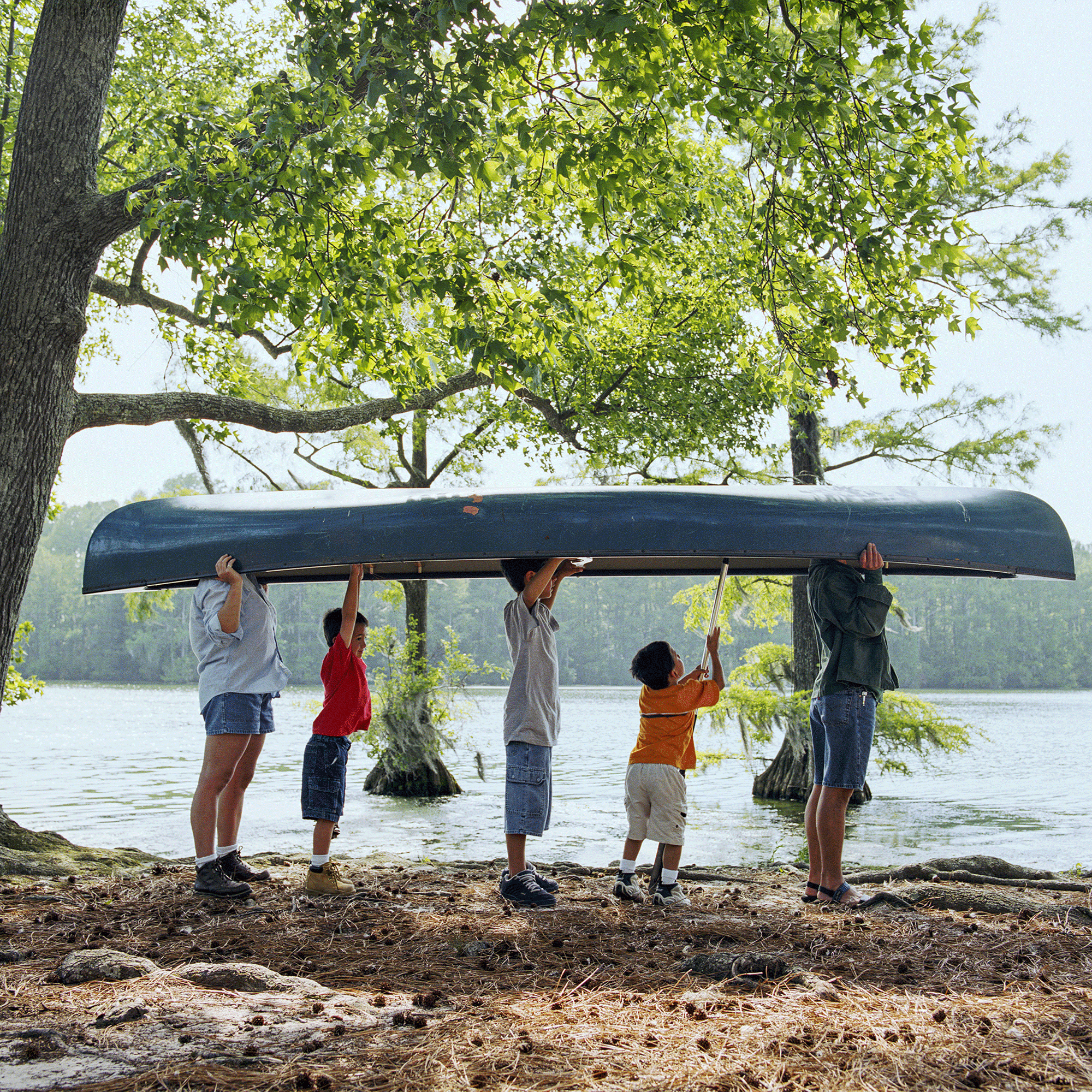 5-köpfige Familie am See, hält ein Kanu umgekehrt über ihren Köpfen