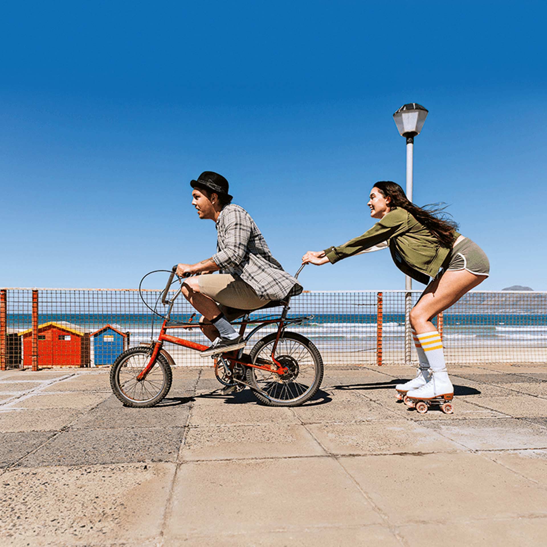 Ein junger Mann und eine Junge Frauen fahren Velo Skates