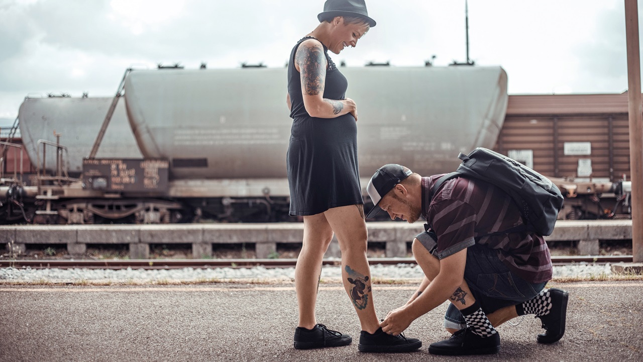 Der Partner bindet der schwangeren Frau die Schuhe