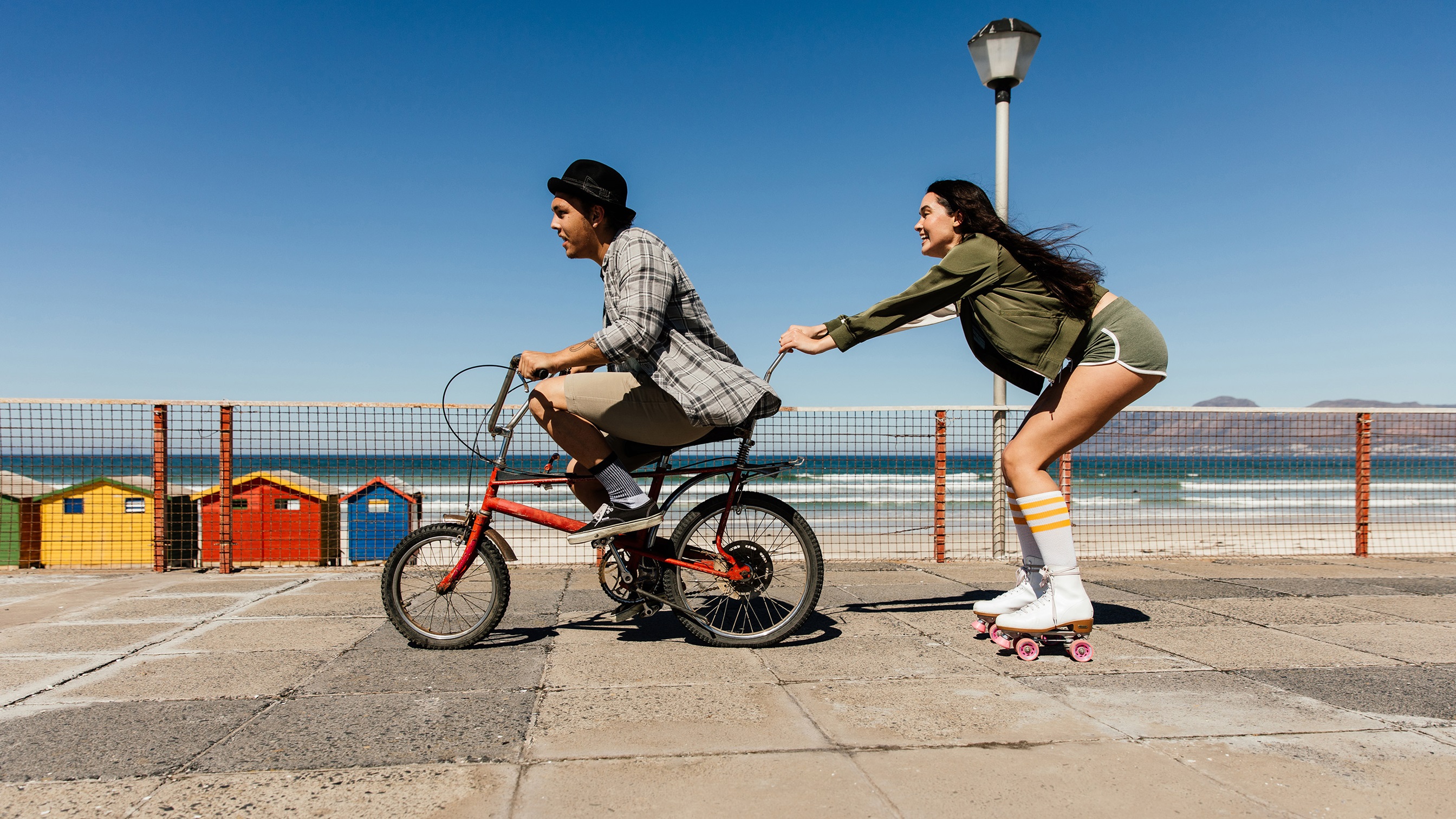 Ein junger Mann und eine Junge Frauen fahren Velo Skates