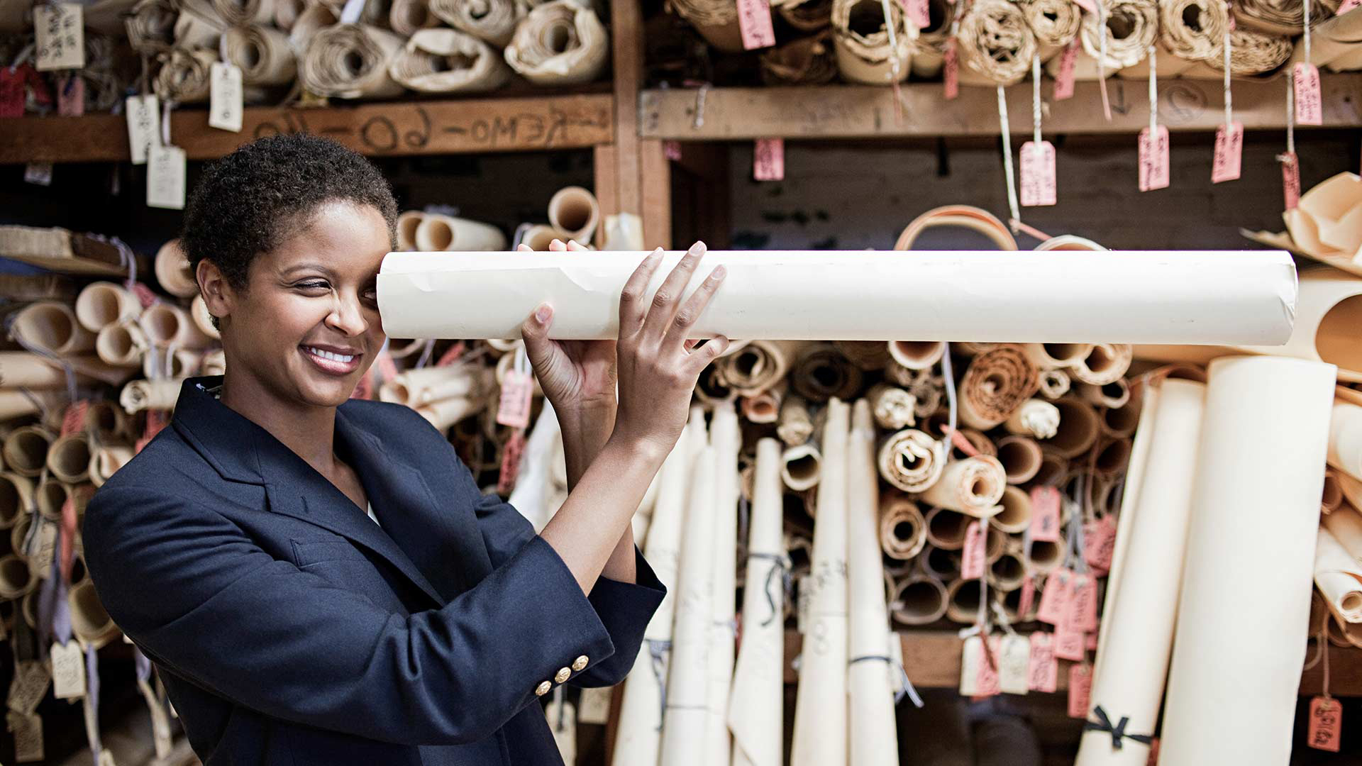 Eine Frau schaut in die Papierröhre hinein