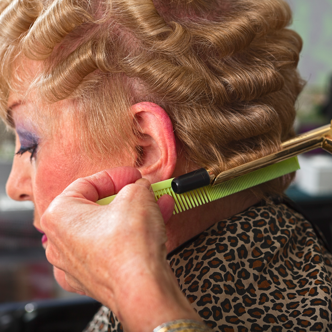 Die Haare einer Dame werden mit dem Lockenstab gelockt