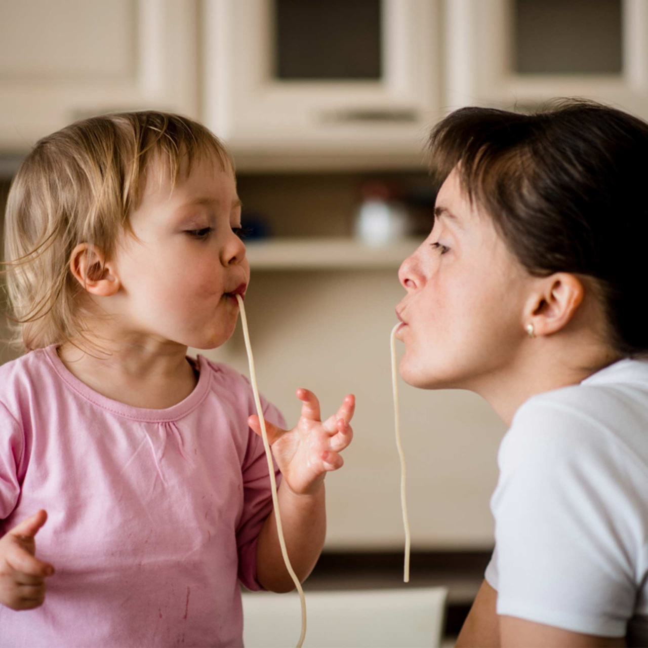 Mutter und Tochter essen an einer Spagetti