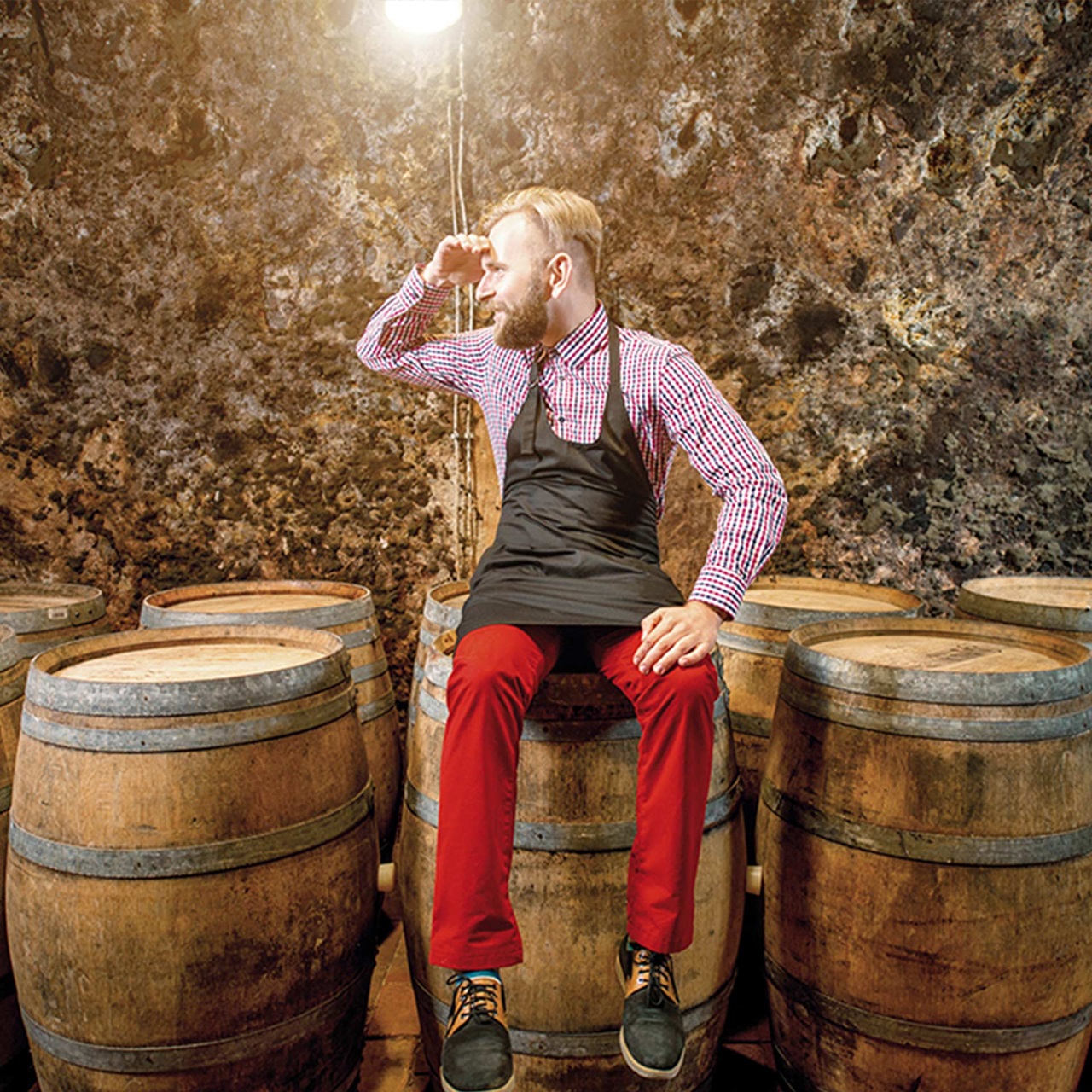 Ein Mann sitzend auf Fässern schaut nach links