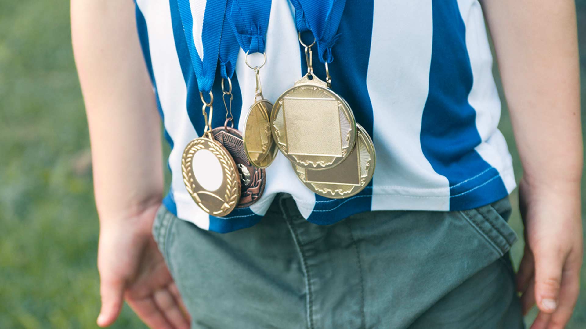 Ein Junge hat seine fünf Medaillen um den Hals gehängt 